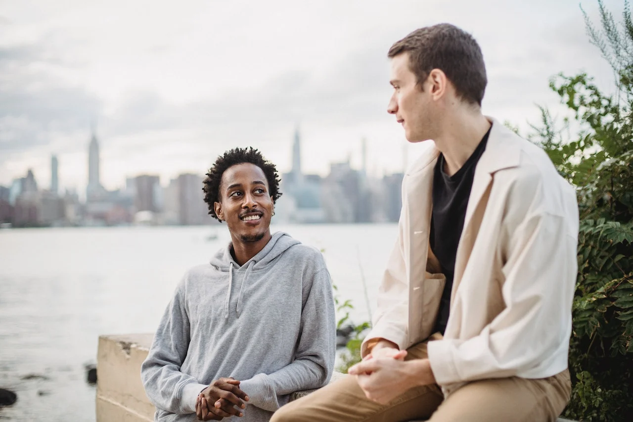 man with his friend talking and smiling outside how to stay positive